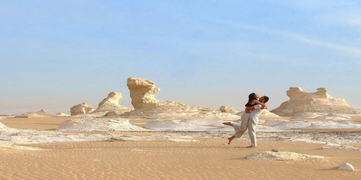 Campers watching the sunset among chalk rock formations in Egypt’s White Desert during a two-day safari from Bahariya Oasis.
