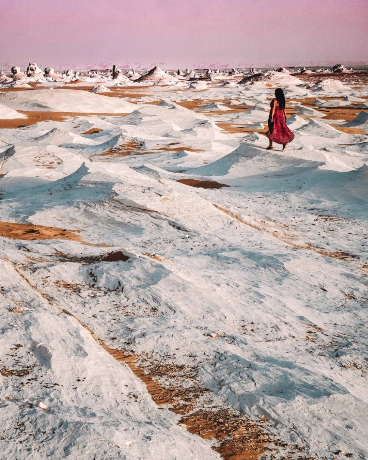 Chalk formations of the White Desert bathed in sunset light, with travelers exploring and camping during a Heart Egypt Tours excursion.