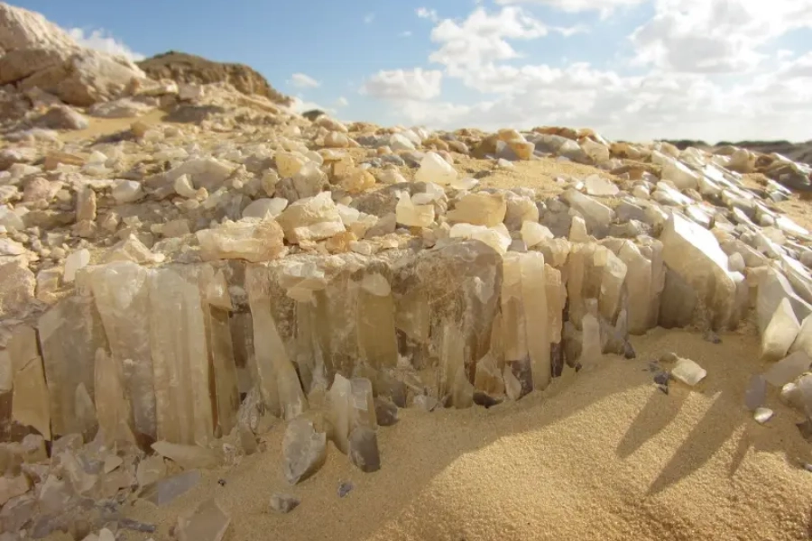 Travelers exploring Crystal Mountain in Egypt’s Western Desert, surrounded by glittering quartz crystals reflecting the golden desert light.