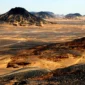 Crystal Mountain and black volcanic dunes in Egypt’s Western Desert with travelers exploring during a Heart Egypt Tours guided trip.