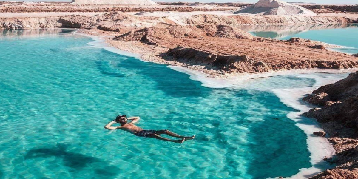 Siwa Oasis at sunset showing salt lakes, palm trees, and desert dunes in Egypt’s Western Desert, photographed during a Heart Egypt Tours trip.